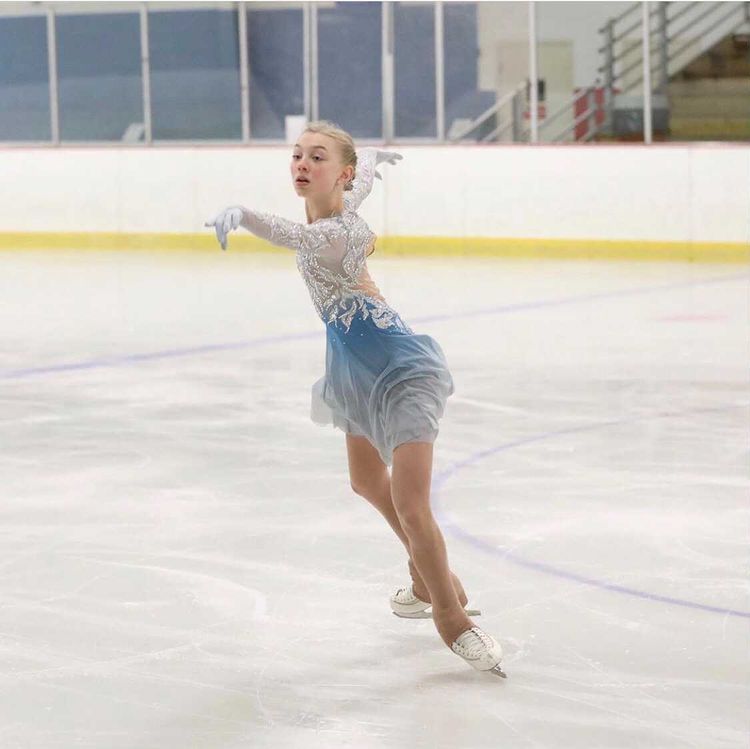 Figure skater performing on ice rink showcasing strength and grace in WaveWear athlete testimonials