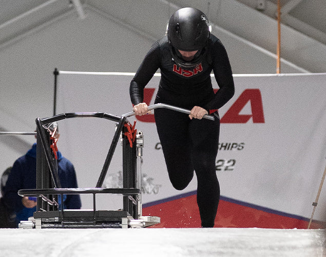 Athlete in Team USA gear pushing a sled in a training session during Lauren Brzozowski Team USA interview