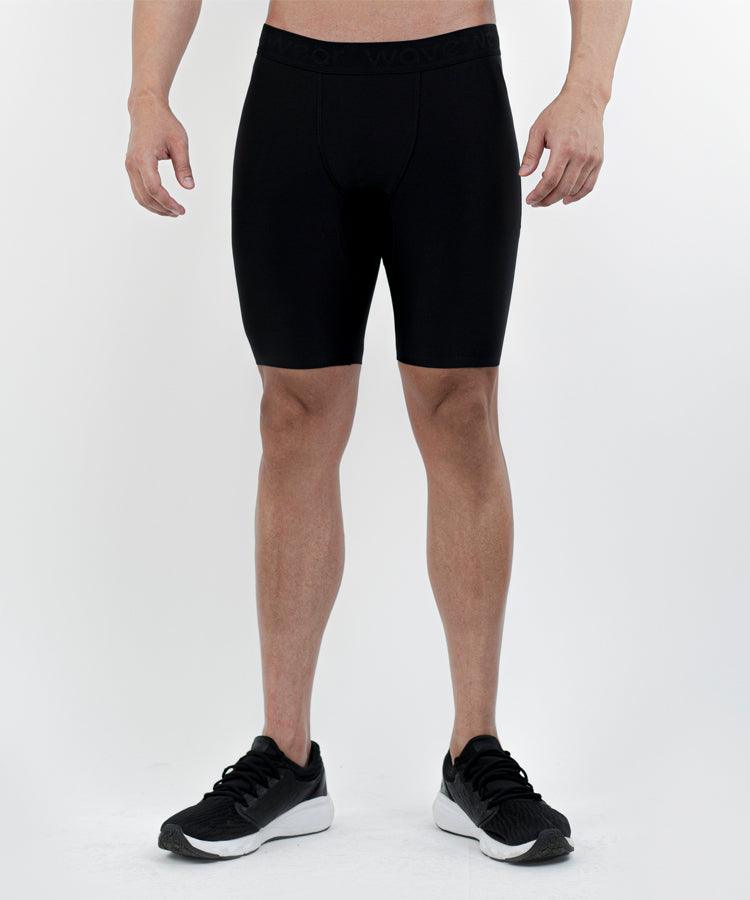 WaveWear men's compression shorts in black worn by a male model with black athletic shoes