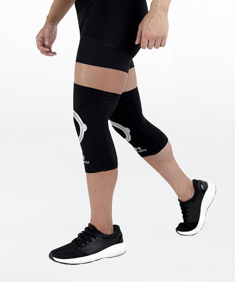 WaveWear black kinesiology knee support sleeve worn on legs with running shoes for athletic use