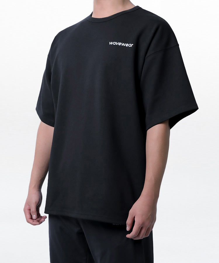 Camiseta de corte oversize Dynamic, primer plano frontal parcial mostrando el logo estampado de WaveWear y el detalle de la manga con hombro caído