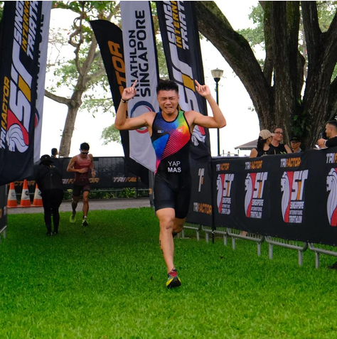 Athlete wearing L20 leggings crossing the finish line at a triathlon event in Singapore