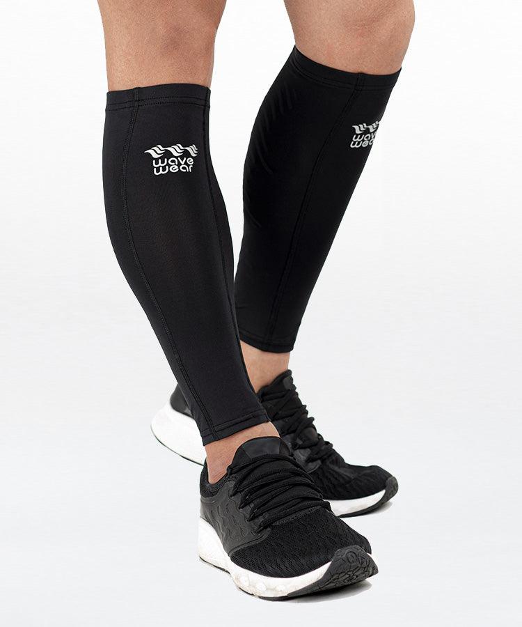 WaveWear C2 Calf Recovery Kinesiology Compression Sleeves in black front view on both legs in standing pose with WaveWear logo