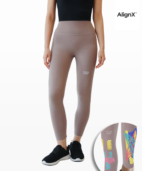 WaveWear kinesiology tape leggings with pockets in taupe color worn with black sneakers and a black top
