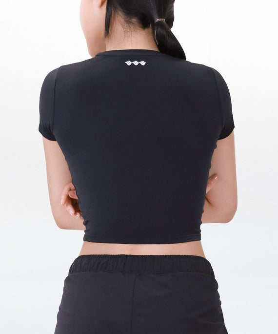 Back view of woman wearing black WaveWear compression crop top for women with short sleeves