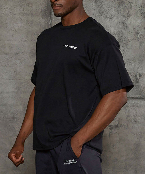 WaveWear black dynamic oversized fit t-shirt worn by male model with small logo on chest