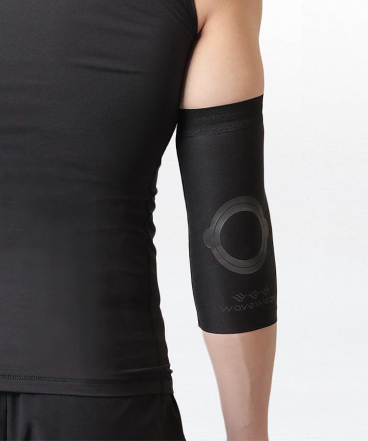 Schwarze E2 Ellenbogenbandage, Nahaufnahme mit rundem Silikon-Griffpad am Ellenbogengelenk