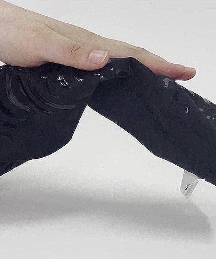 L30 Compression Leggings close-up of 4-way stretch fabric material being stretched showing kinesiology tape texture and flexibility