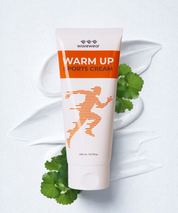 WaveWear Warm Up Sports Cream 200ml tube with orange runner graphic and fresh centella asiatica leaves on white background