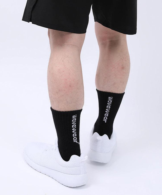 WaveWear black compression athletic socks worn with white sneakers on a person's legs