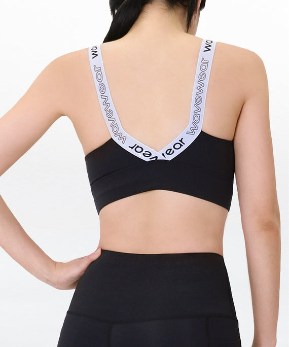 WaveWear black compression sports bra with branded white adjustable straps shown from the back