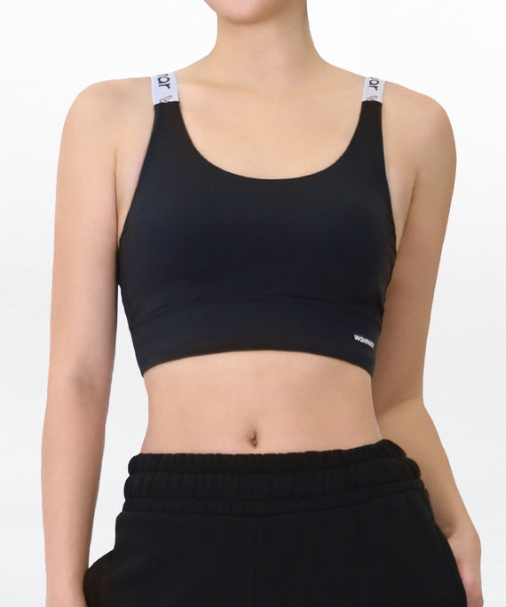 WaveWear black compression sports bra with white adjustable straps worn with black pants