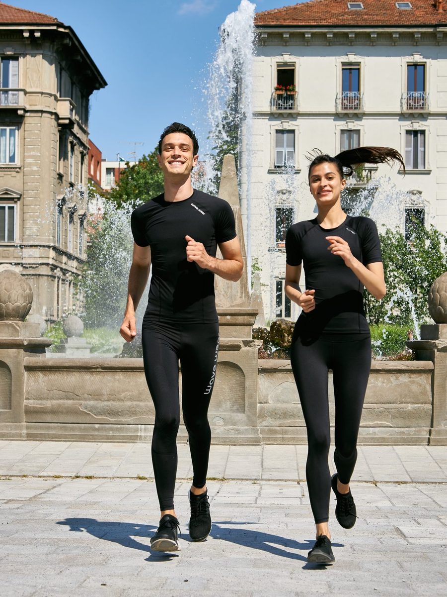 Man and woman jogging toward the camera in WaveWear tops and tights