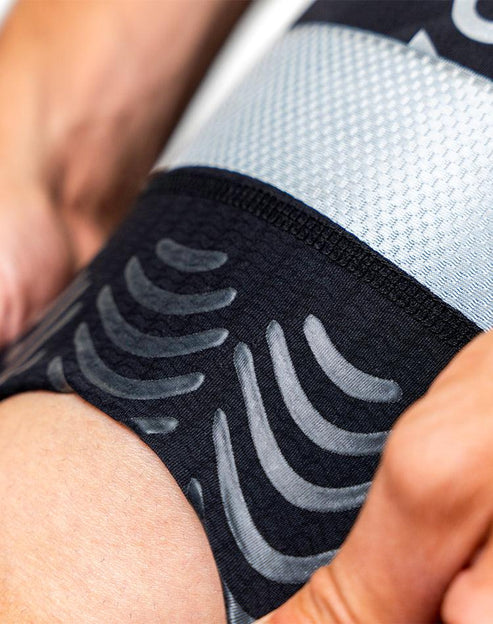 Endeavor Cycling Bibshorts macro close-up of AlignX kinesiology tape pattern on thigh showing adhesive support structure